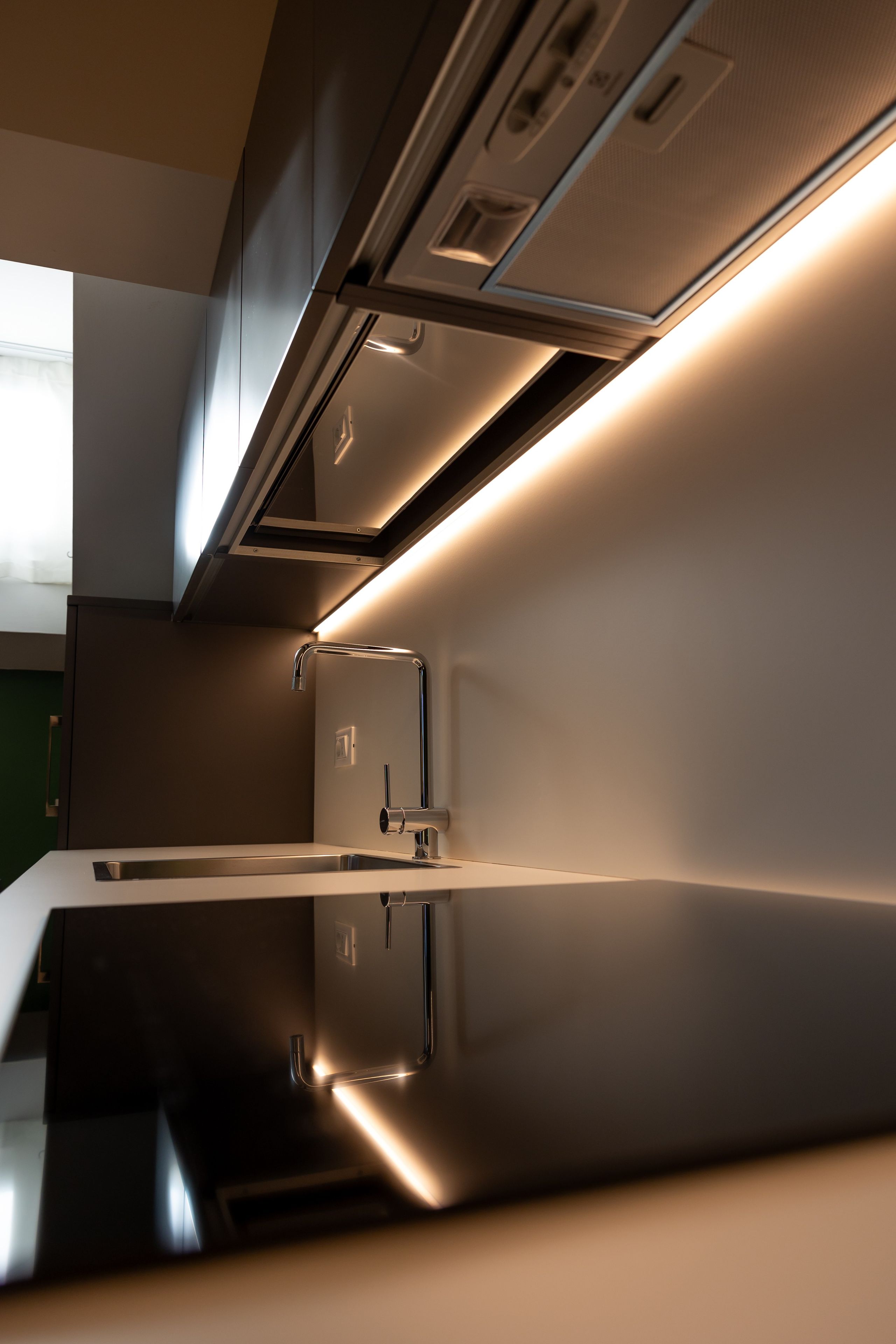 Una cocina moderna con electrodomésticos de acero inoxidable e iluminación debajo de los gabinetes.