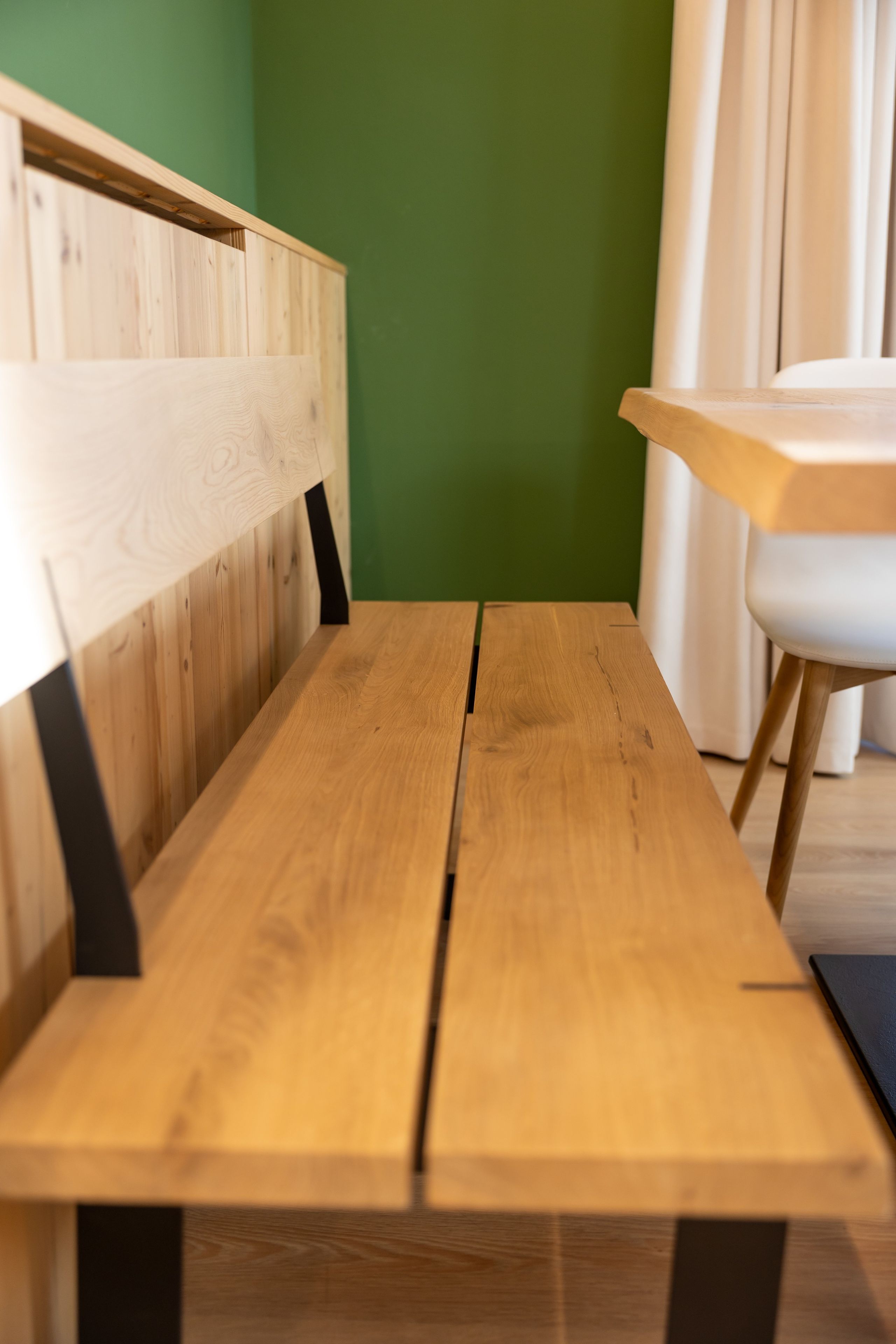 Eine Holzbank mit Rückenlehne und einem Tisch davor.