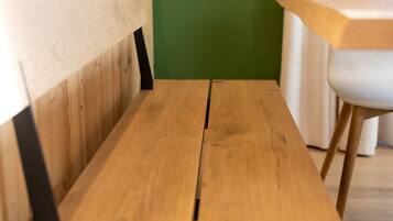 Eine Holzbank mit Rückenlehne und einem Tisch davor.