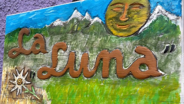 Un letrero con el texto 'La Luna' e ilustración de un sol.