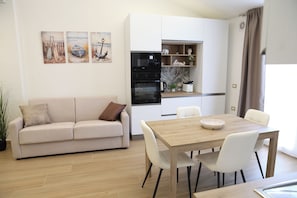 Ein zeitgemäßer Wohnbereich mit Sofa, Esstisch und Küchenzeile.