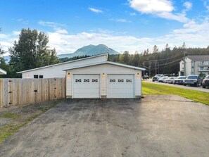 A two-car garage with a wooden fence and a mountain in the background.