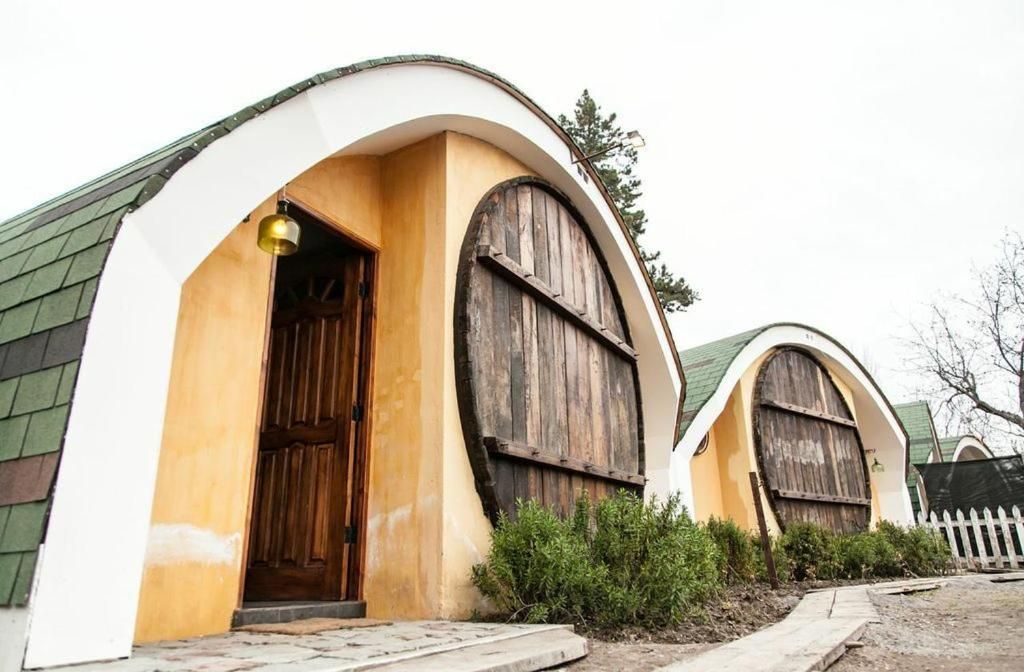 Um edifício com um telhado em arco distinto e uma porta de madeira.