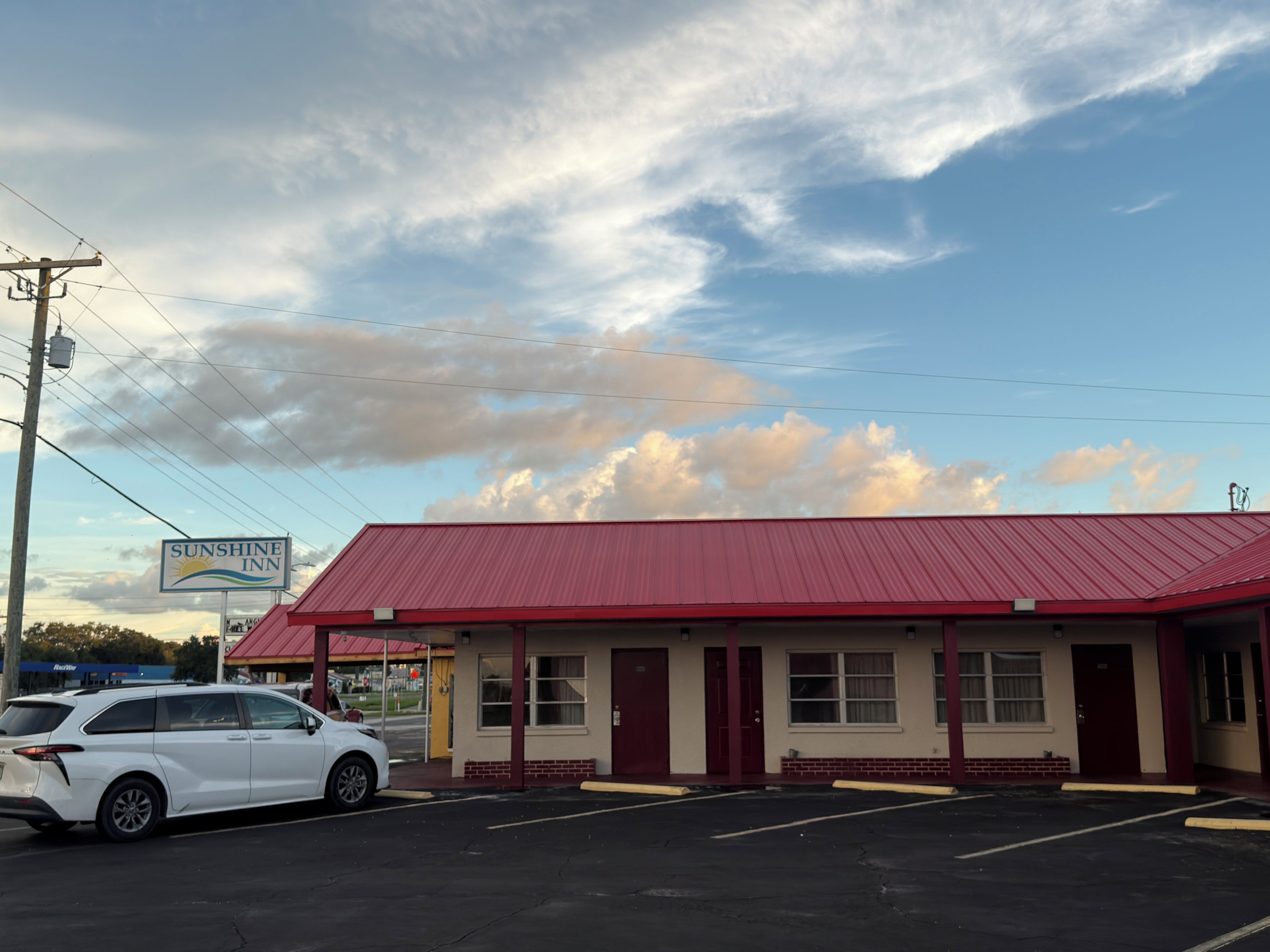 Un edificio con techo rojo y un cartel que dice 'Sunshine Inn'.