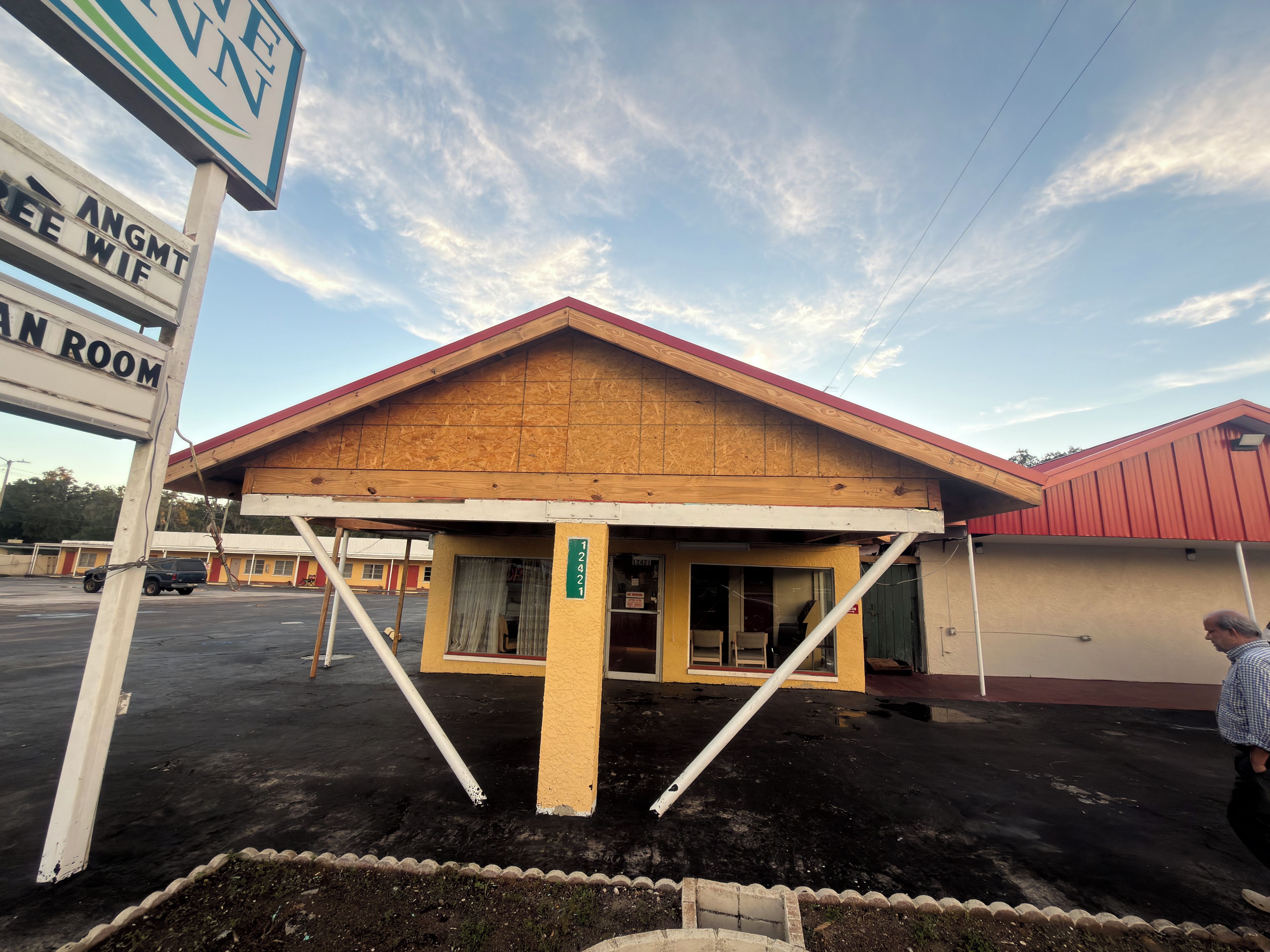 Un motel con techo rojo y entrada cubierta.