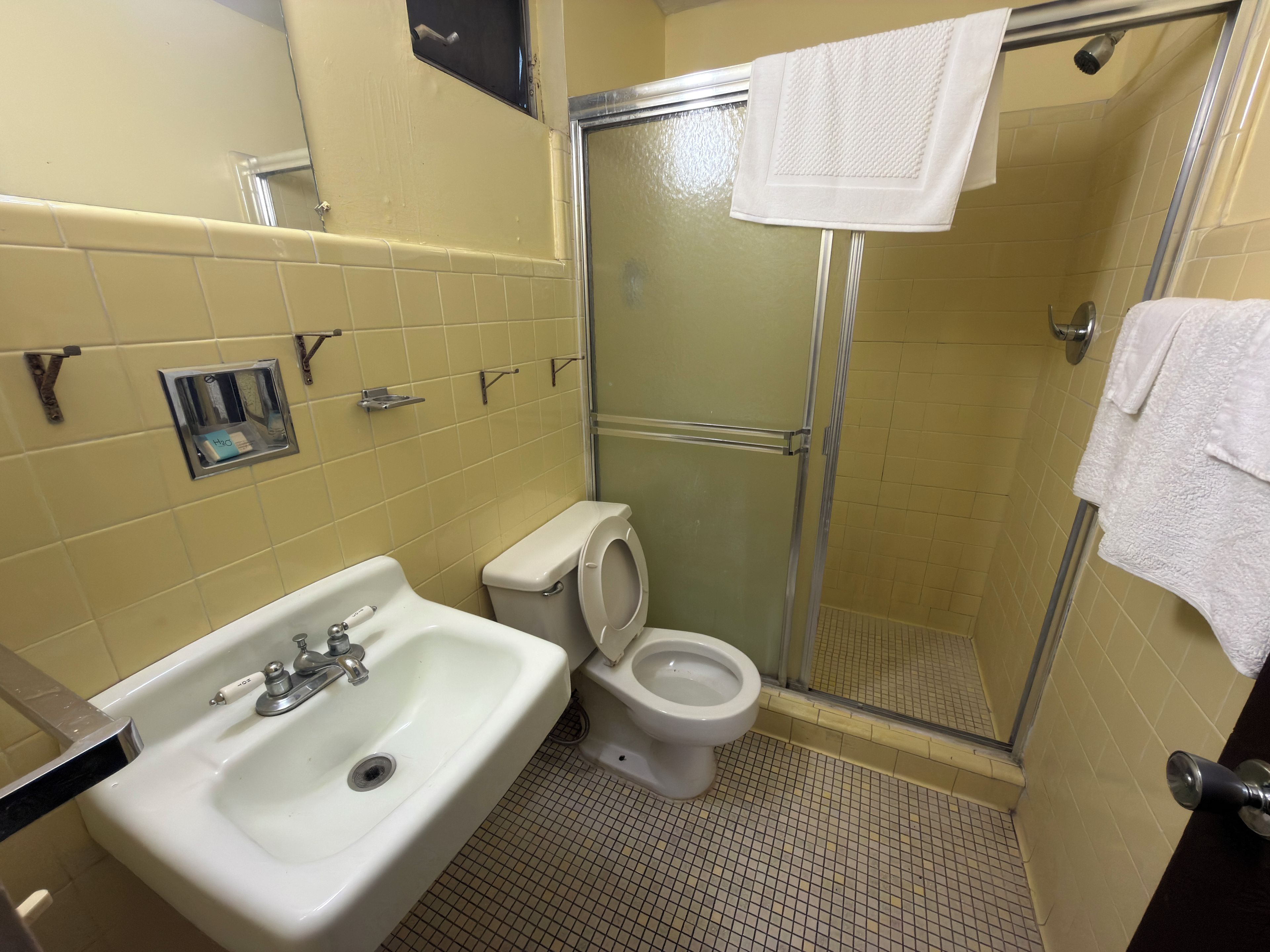 Ein Badezimmer mit Waschbecken, Toilette und Duschkabine.