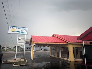 A Sunshine Inn with a red roof and a signboard.