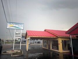 Un Sunshine Inn con techo rojo y un letrero.
