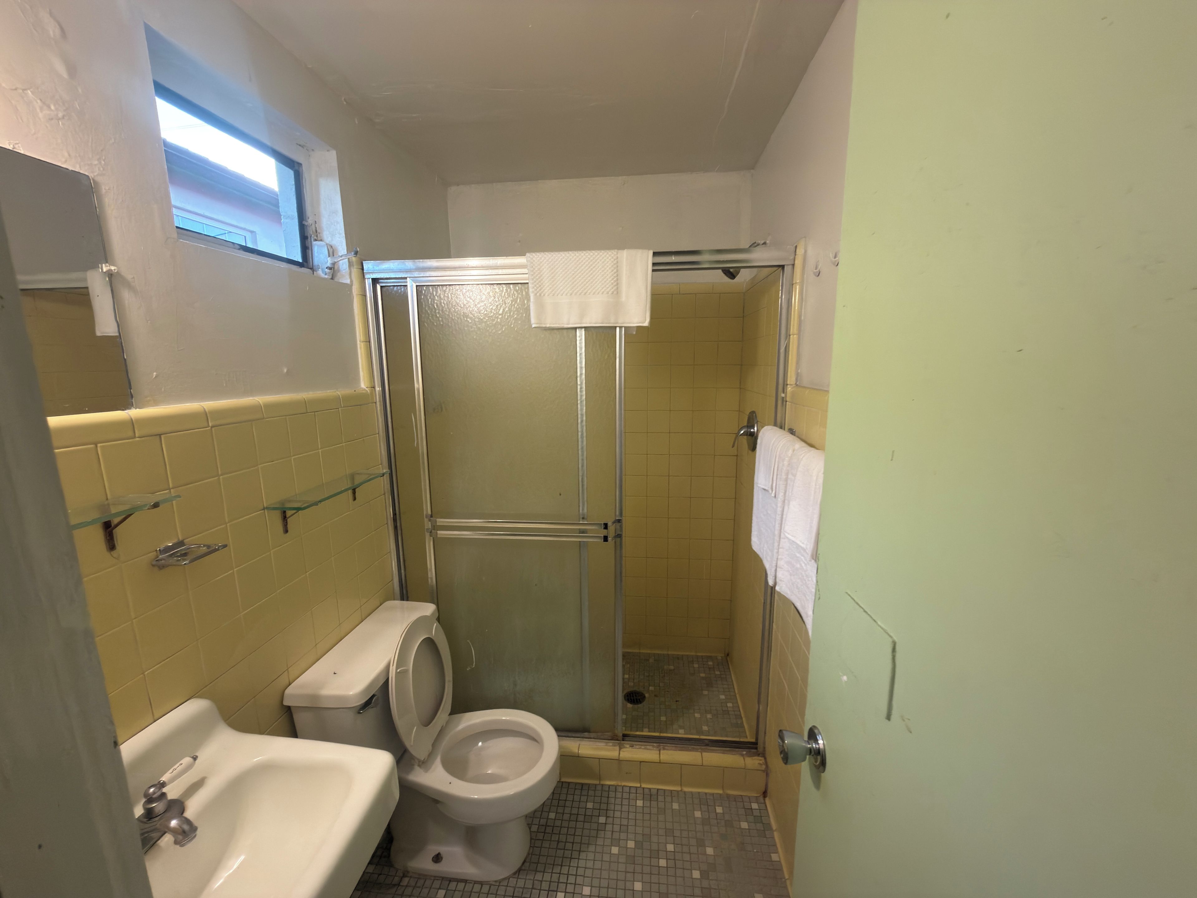 Un baño con inodoro, lavamanos y cabina de ducha.