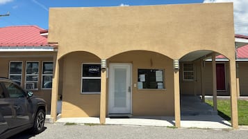 Un edificio con fachada color crema, techo rojo y un cartel que dice 'VACANCY'.