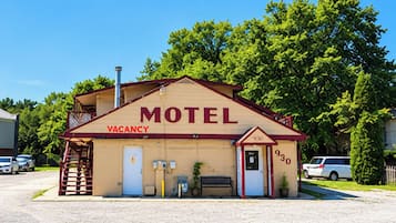 Un motel con un cartel de 'VACANCY', el número '930' en la puerta y una chimenea.
