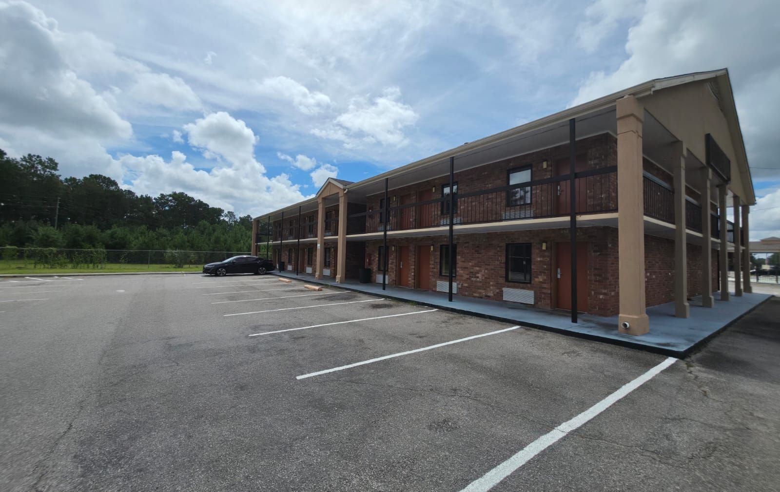 A multi-story building with a parking lot in front.
