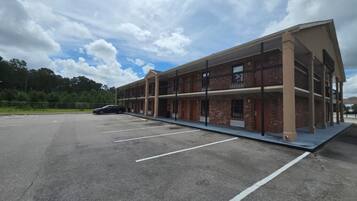 A multi-story building with a parking lot in front.