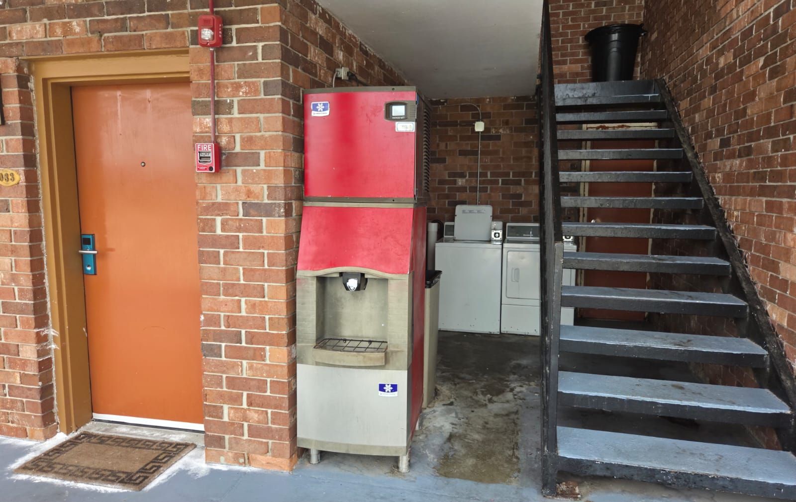 A fire extinguisher, a water dispenser, a staircase, and a laundry area.