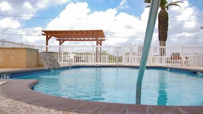 A swimming pool with a wooden deck and a white fence. - Rockport RV Resort (Rockport)