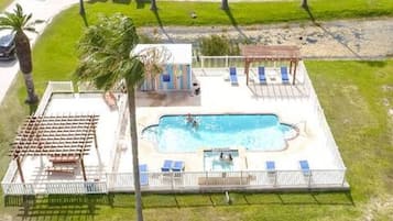 Une piscine dotée d’un solarium, de chaises longues et d’un espace abrité.
