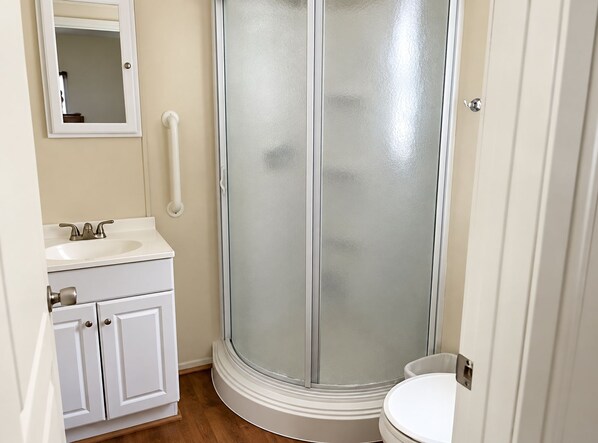 Une salle de bain avec un lavabo blanc, un miroir et des toilettes.