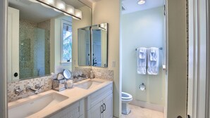 A bathroom with a double sink vanity, a large mirror, and a shower area. - VILLA AZURE (Blue Mountain)