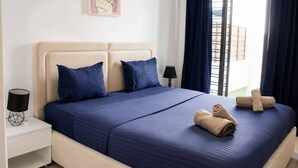 A hotel room with a bed, two pillows, a nightstand with a lamp, and a window with curtains. - Luxury Apartment, one Bedroom, Prestigious Residence (La Marsa)