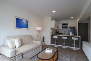 Ein modernes Wohnzimmer mit einer Couch, einem Couchtisch und einem Bild an der Wand.