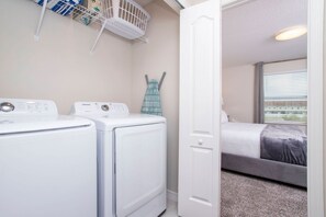 A laundry room with two white washing machines and a drying rack. - 3BR Townhome in Fiesta Key Near Disney Parks (Kissimmee)