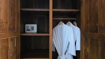 Un armario de madera con radio incorporada y batas blancas colgadas en un perchero.