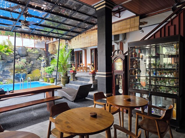 A restaurant with outdoor seating, a pool, and a display of various items.