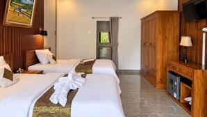 Habitación de hotel con dos camas, un televisor, un armario y un cuadro en la pared.