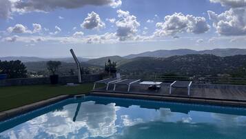A swimming pool with a view of mountains and a clear sky.