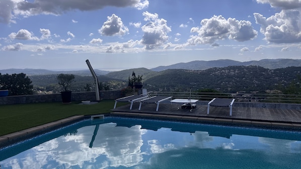 A swimming pool with a view of mountains and a clear sky.