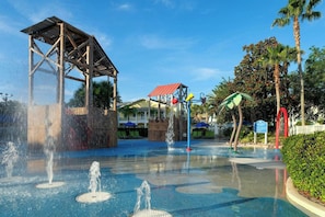 Un espace de jeux aquatiques doté de plusieurs fontaines et d’une structure abritée.
