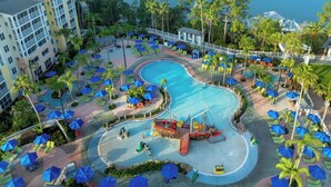 Ein Resort mit großem Pool, Liegebereichen mit Sonnenschirmen und Blick auf den Ozean.