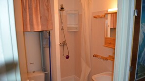 Een badkamer met een douche, toilet en wastafel.