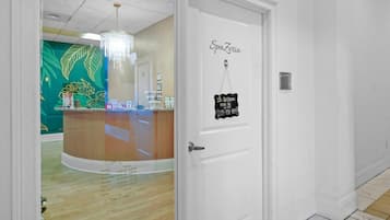 A reception area with a closed sign, a SpaZeria sign, and a closed hours sign.