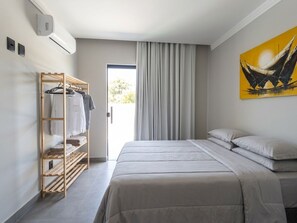 Ein Hotelzimmer mit Bett, Schrank und einem Gemälde an der Wand.