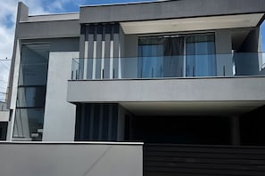 Ein modernes mehrstöckiges Gebäude mit großen Fenstern und einem Balkon.