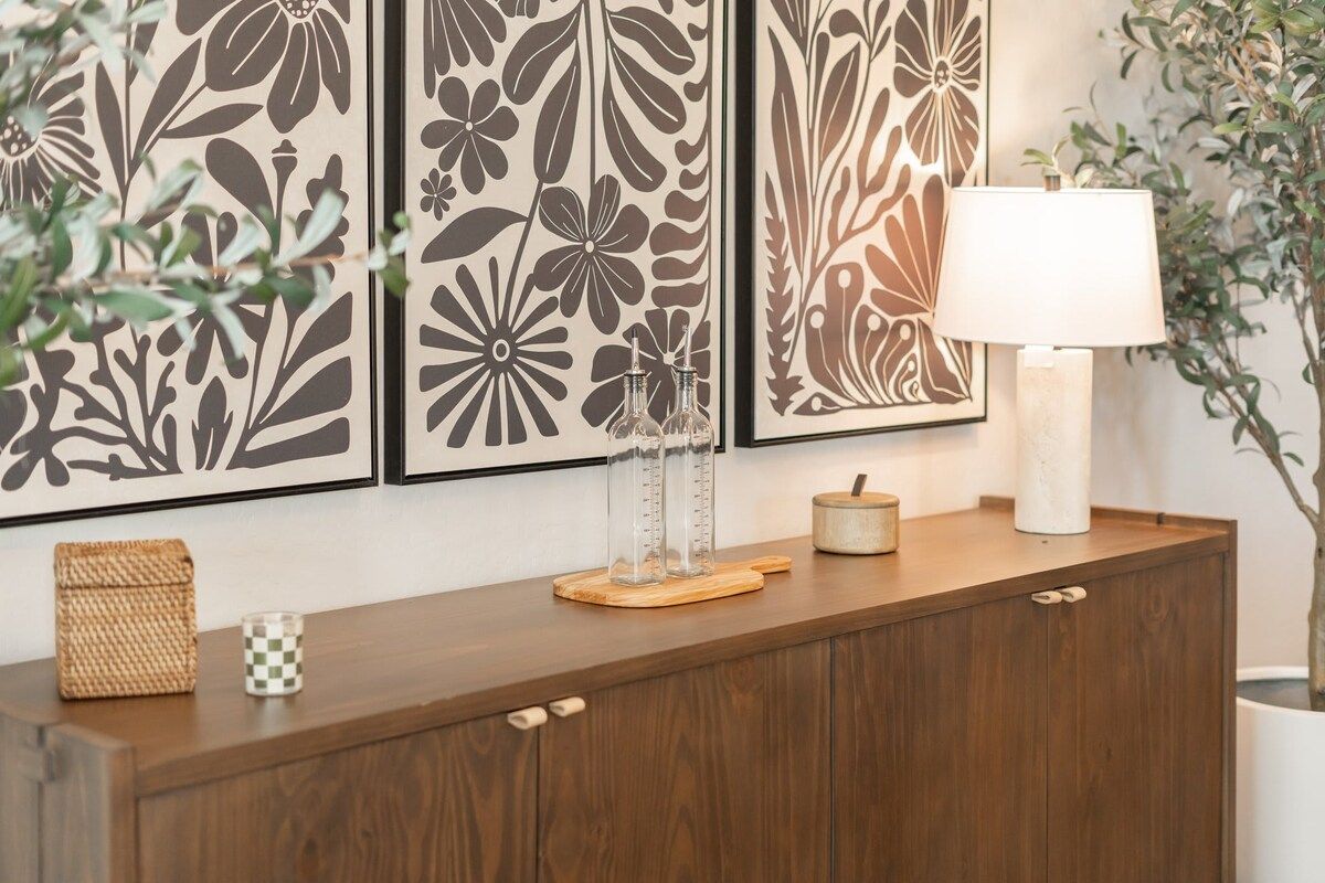 Un meuble en bois orné de panneaux décoratifs, une lampe et une plante en pot.