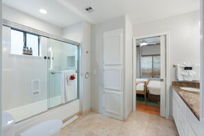 Ein modernes Badezimmer mit einer Duschkabine, einer Toilette und einem Waschbecken mit Arbeitsplatte.