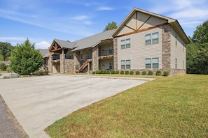 A two-story building with a stone facade, a covered front porch, and a parking lot.