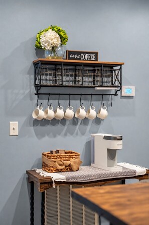 A kitchen area with a coffee station, including a coffee maker, cups, and a basket. - Cades Cove Paradise | Views, Fireplace & MORE! (Townsend)