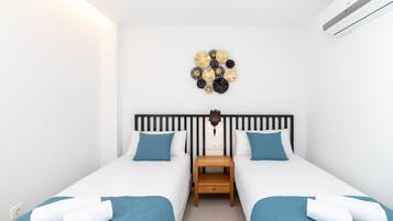 Une chambre d’hôtel avec deux lits, une lampe fixée au mur et un élément décoratif mural.