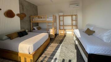 A hotel room with two beds, a ceiling fan, and built-in shelves.