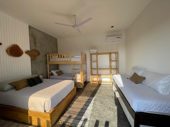 A hotel room with two beds, a ceiling fan, and built-in shelves.