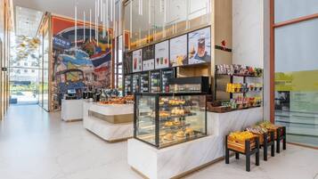 A food court with various food displays and a mural on the wall.
