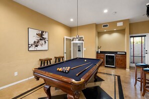 A pool table with balls, a billiard cue, and a pool table cloth. - Luxury 5BR Retreat, Heated Pool, Spa, Sport Court, Putting Green & Game Rooms (Scottsdale)