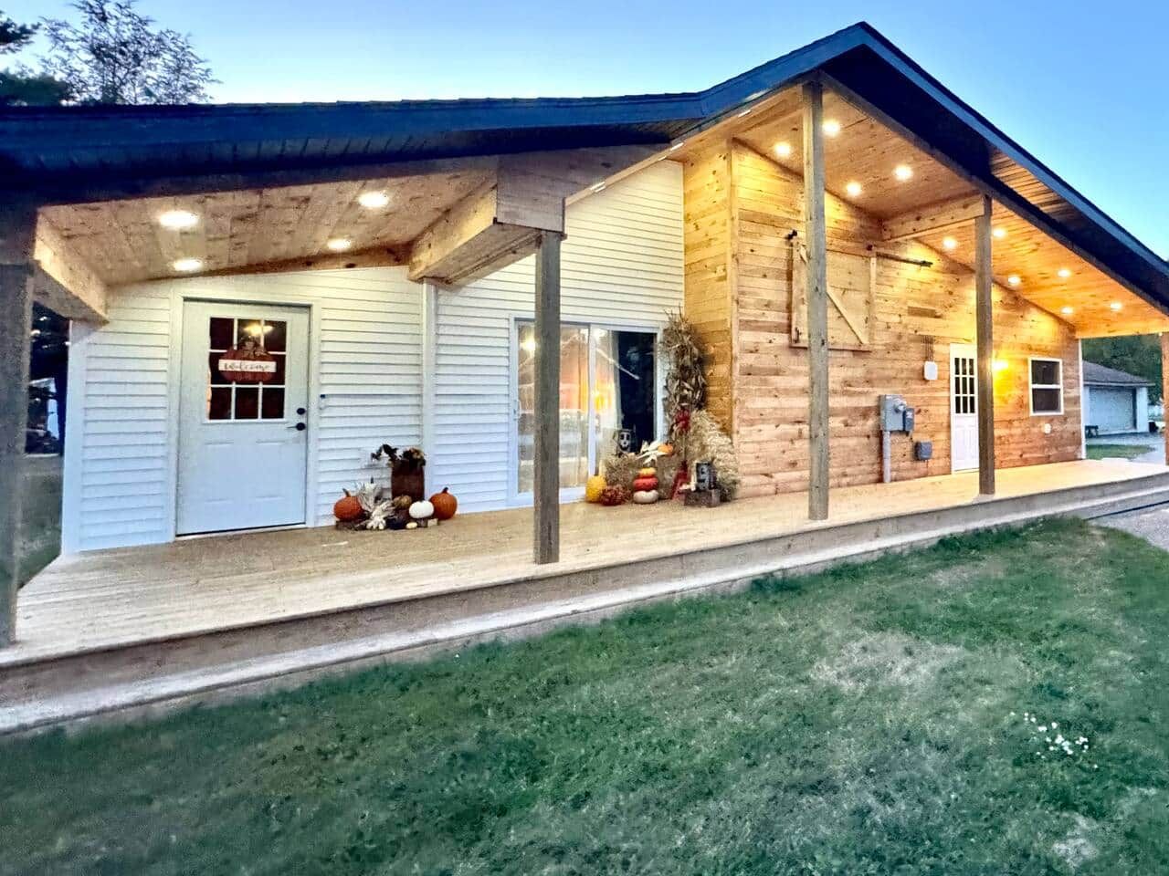 Un bâtiment en bois doté d’un porche, d’une porte et d’un petit arbre décoré.