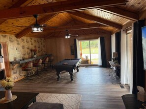 Ein Billardtisch in einem Raum mit Holzböden und einer geneigten Decke.