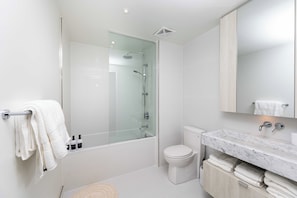 A modern bathroom with a glass-enclosed shower, a toilet, and a marble countertop with a sink. - Stylish Yorkville 1BR Central & Convenient (Toronto)