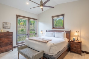 A bedroom with a large bed, two bedside tables, a bench, and a ceiling fan. - Pet Friendly Mountain Retreat | Private Hot Tub | Private Firepit | Direct Trail Access (Silverthorne)