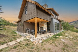 A modern two-story house with a covered patio, stone pathway, and a fireplace. - Pet Friendly Mountain Retreat | Private Hot Tub | Private Firepit | Direct Trail Access (Silverthorne)